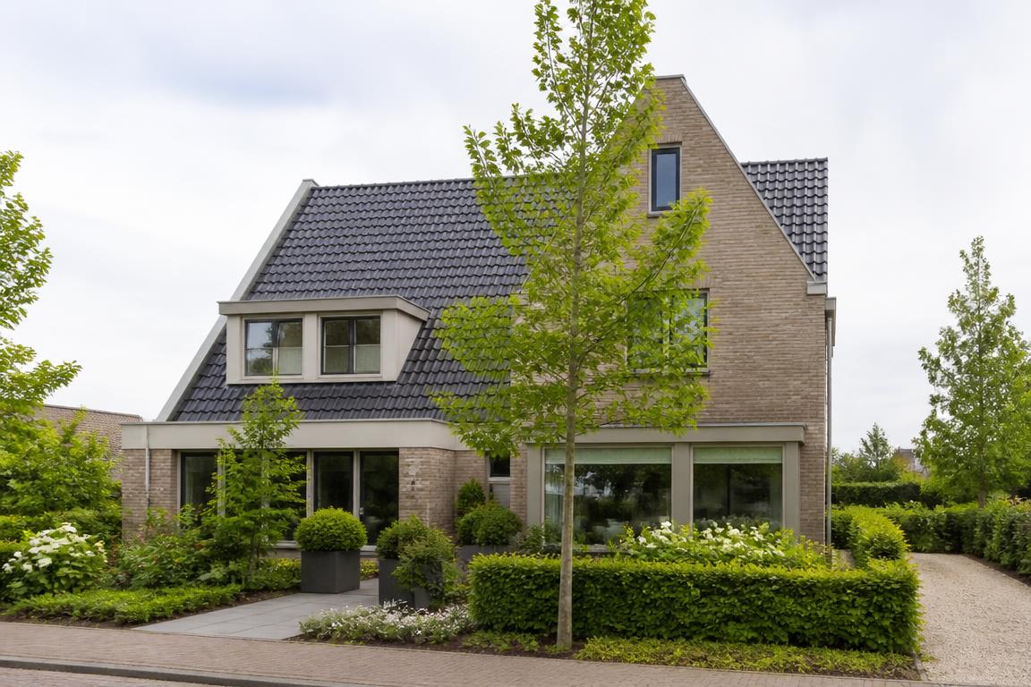 Moderne Nederlandse woning met een groene voortuin